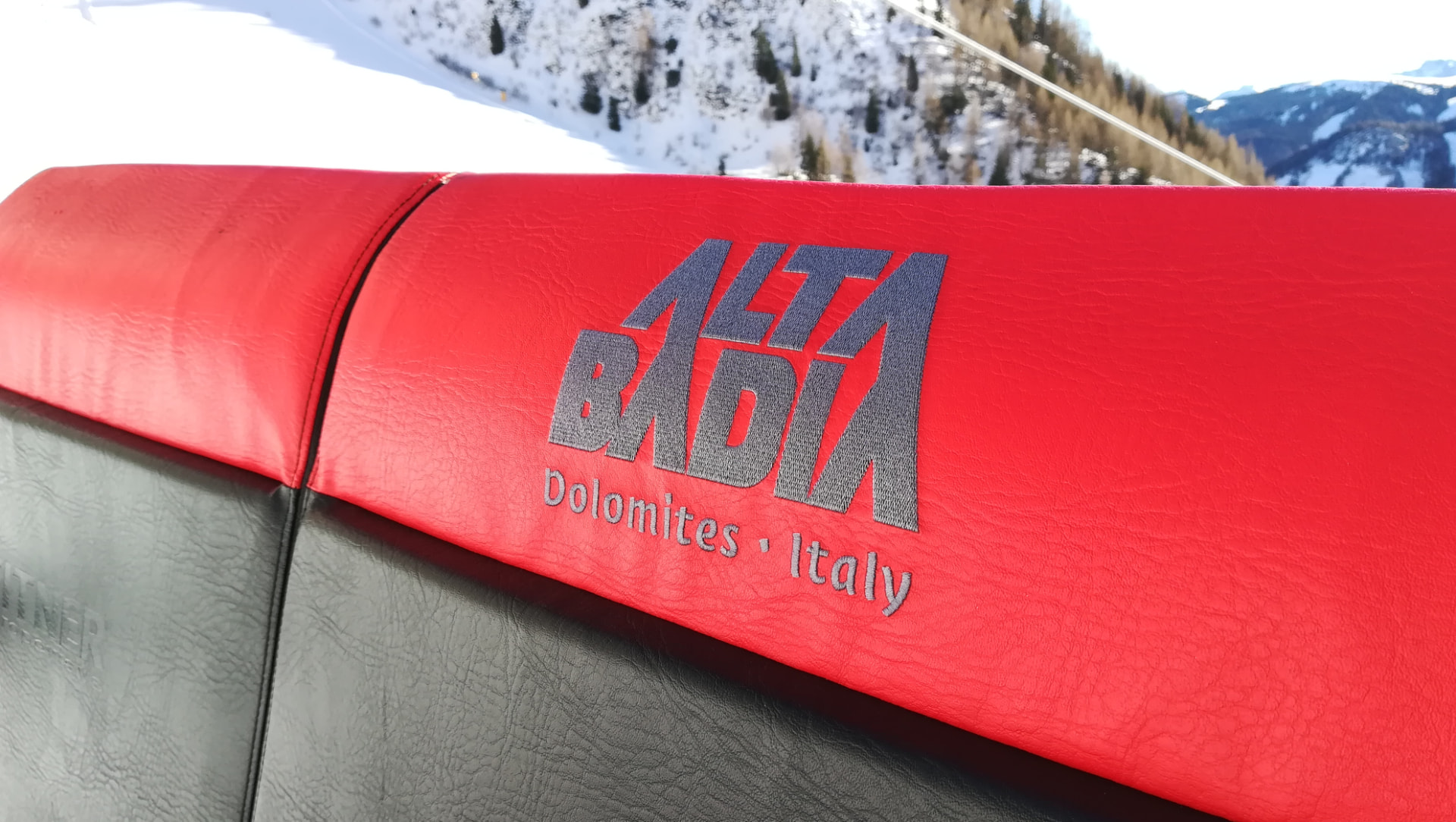 Alta Badia chairlift seat in bright winter sun, snow-covered slopes behind
